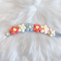 Decorated with crocheted colorful flowers in pink, light blue, orange and white